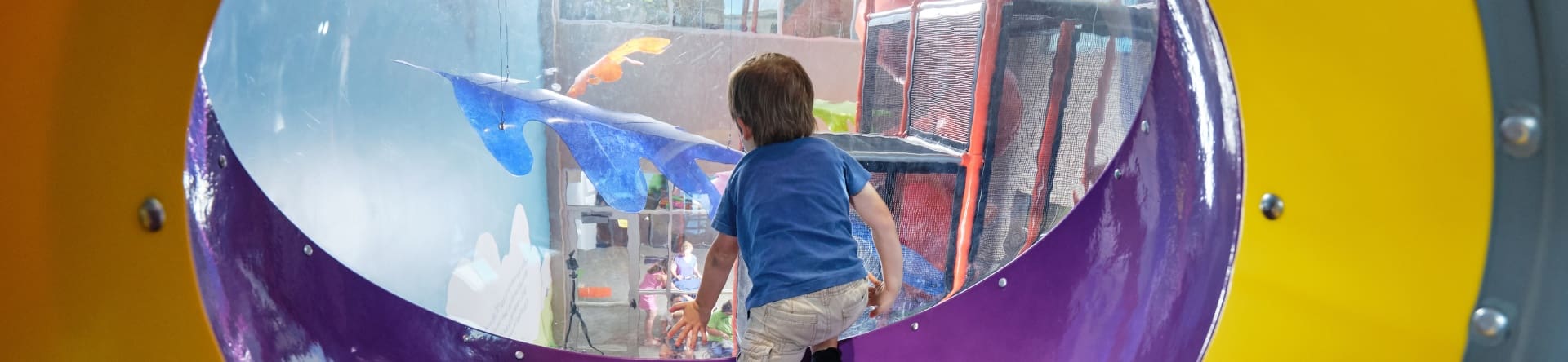 boy looking through viewport at a playground