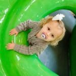 toddler age girl playing on soft play playground