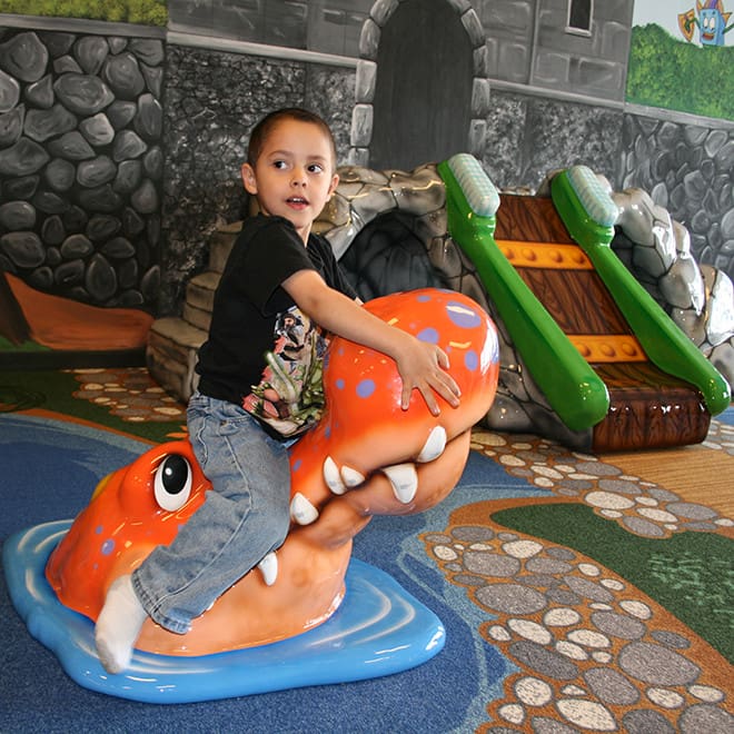 kid playing on adventure dental play equipment