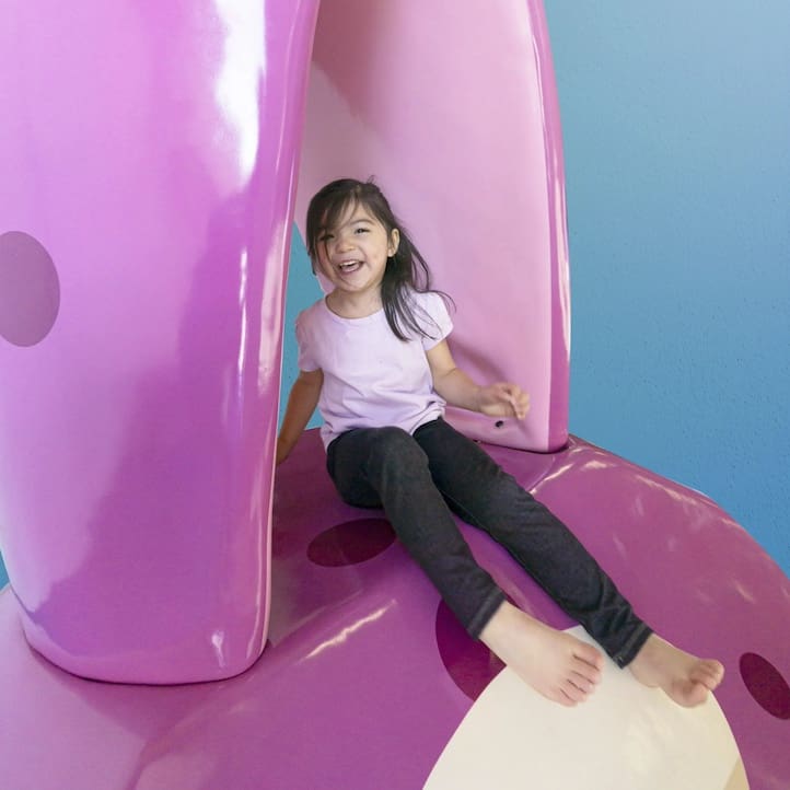 kid playing on big play sculpture