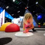 kid playing with interactive play equipment