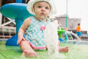 baby sitting on a soft play splash pad