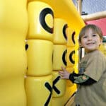 little boy playing at tik tac toe play panel