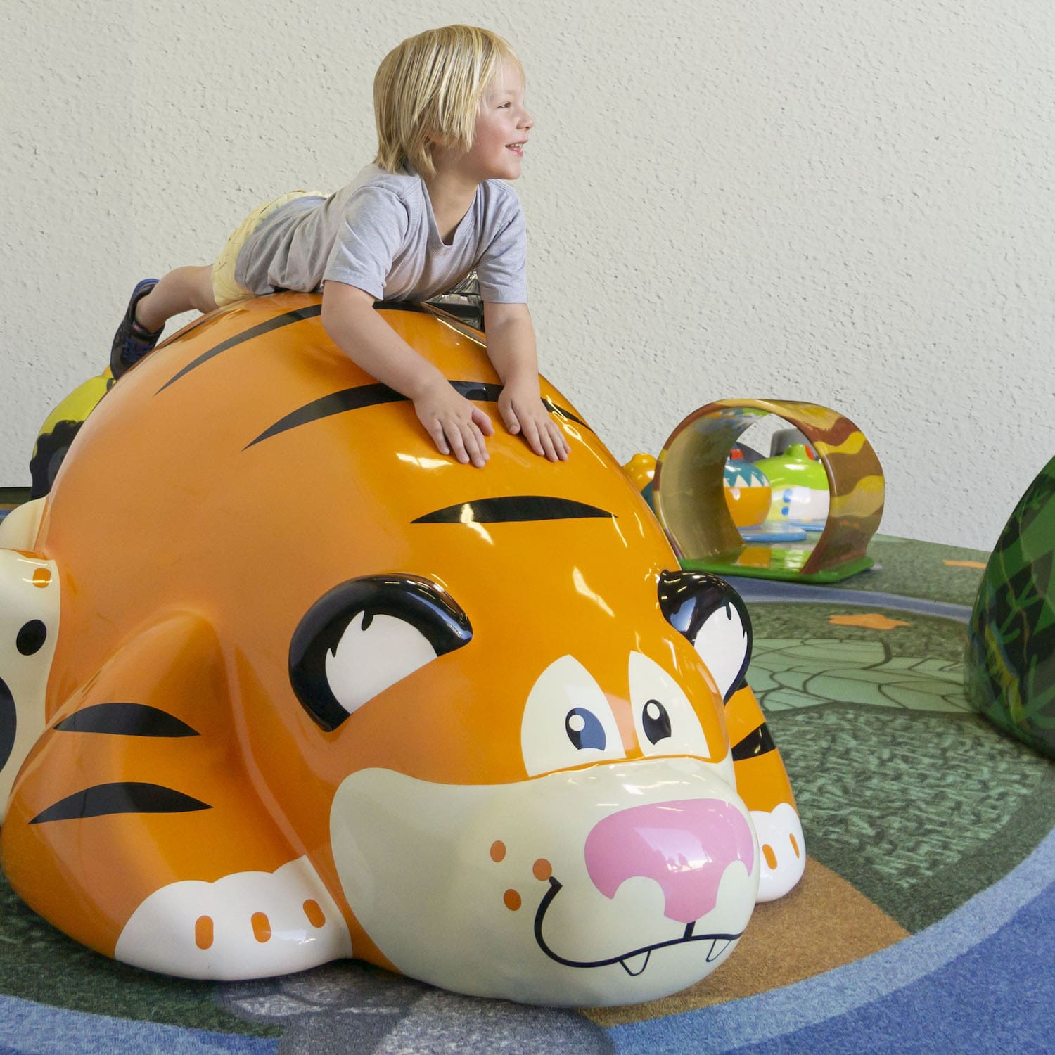 young child playing on the Toonies tiger