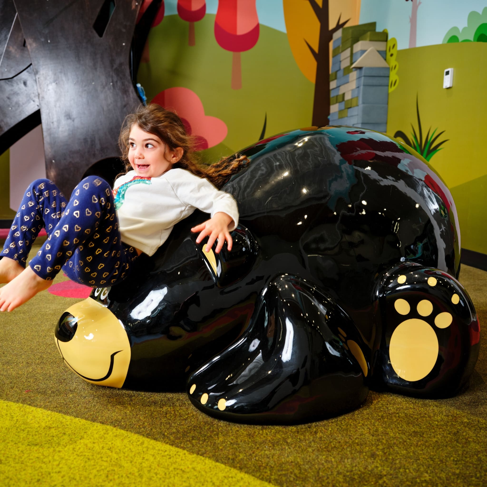 girl sliding down a Toonie bear, playground soft sculpture