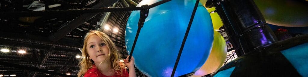 girl playing in the Hive indoor obstacle course playground